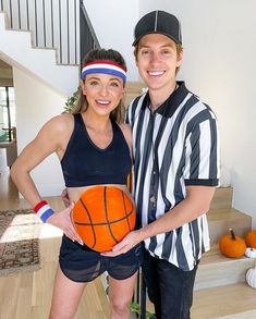 a man and woman standing next to each other holding a basketball