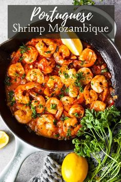 a skillet filled with shrimp and lemons on top of a table next to some parsley