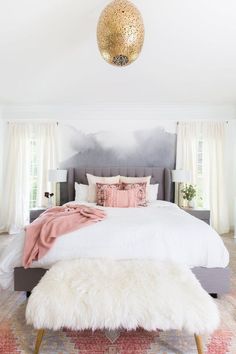 a bedroom with a large bed and white fur rugs