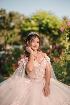 a woman in a wedding dress posing for the camera with her hand on her shoulder