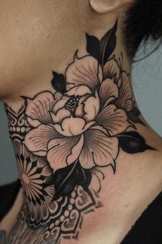 a woman's neck is adorned with black and white flowers