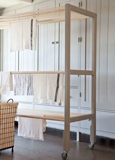 an empty room with clothes hanging on the wall and a basket in front of it