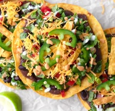 three tortillas topped with black beans, green peppers and shredded cheese on top