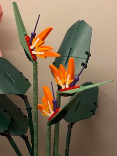 there are three flowers made out of paper and plastic sticks in the shape of umbrellas