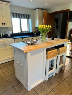 a kitchen with a center island in the middle and yellow flowers on the counter top