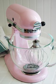 a pink mixer sitting on top of a counter