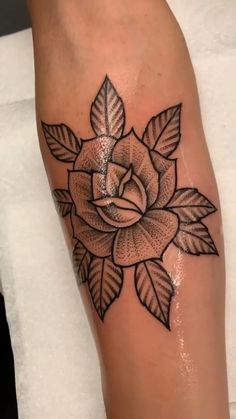 a black and white rose tattoo on the leg