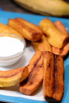 some bananas are sitting on a plate with dip