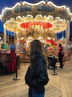 a woman standing in front of a merry go round