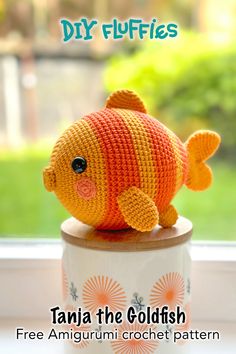 an orange crocheted fish sitting on top of a cup with the words, free amigurmi crochet pattern