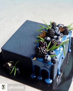 a blue cake with berries and pineapples on top