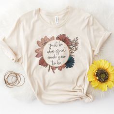 a t - shirt with the words trust be who god hands you in love on it next to a sunflower