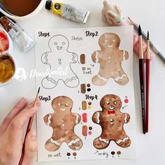 someone is painting gingerbreads on paper with watercolors and crayons