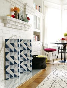 a living room with white brick fireplace and blue geometric tiles on the wall above it