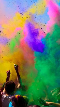 people are throwing colored powder in the air at a color run or holi festival