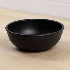 a black bowl sitting on top of a wooden table