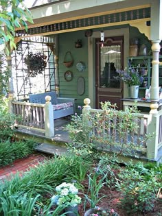 the front porch is covered with plants and flowers