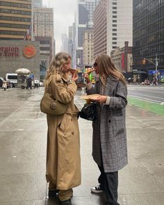 two women standing in the rain talking to each other