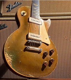 an old guitar sitting on top of a piece of luggage