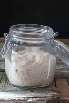 a jar filled with white stuff sitting on top of a wooden table