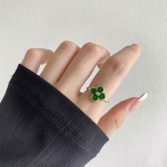 a woman's hand with a ring on it and four leaf clovers in the middle