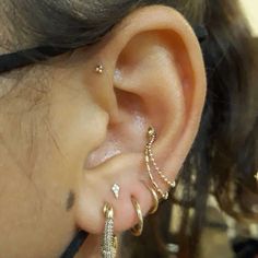 a close up of a person's ear with three different types of piercings