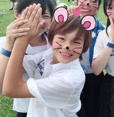 four children with bunny ears on their faces posing for a photo in front of the camera