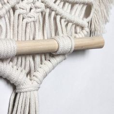 a close up of a piece of white rope with a wooden handle on the end