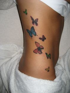 a woman's stomach with colorful butterflies on her lower back and the bottom part of her body