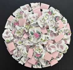 several pieces of pink and white paper with flowers on them are arranged in a circle