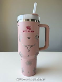 a pink coffee cup with a straw in it on top of a white countertop