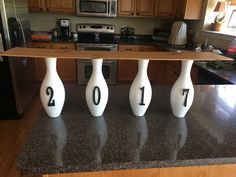 three white vases sitting on top of a counter in a kitchen next to a stove