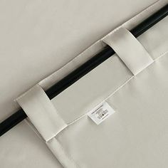 the back end of a bed with a white sheet and black stick attached to it