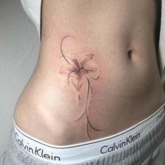 a woman's stomach with a flower tattoo on her belly and the words, calvinklen written below it