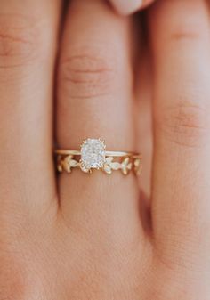 a woman's hand with a ring on it and a diamond in the middle