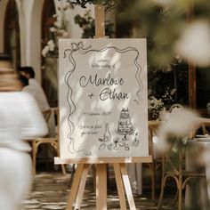 an easel with a wedding sign on it in front of some tables and chairs