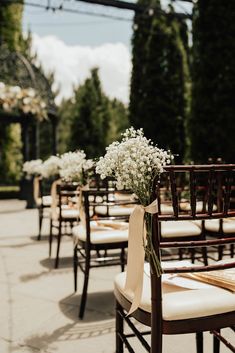 rows of wooden chairs with white flowers on them