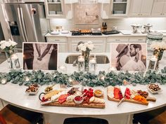 a table topped with pictures and food on top of a white kitchen counter next to a refrigerator