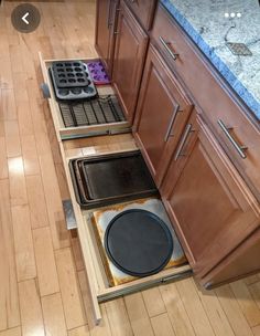 an open drawer in the middle of a kitchen