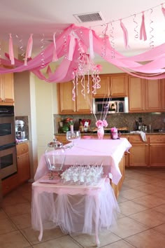 a kitchen with pink and white decorations hanging from the ceiling