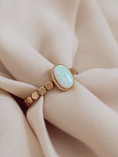 The romantic and gorgeous Oval Opal Ring is the focus of this handmade ring. It’s a Unique white fire opal stone, Man-made opals have fewer flaws and a lighter carbon footprint. This beautiful opal ring is a gift or gift for yourself, it will illuminate your best qualities and bring forth creativity and inspiration. Details: 14K gold filled & sterling silver band: hammered style gemstone: white fire opal measures stone: 6mm x 8mm. measure band: approx 2.3mm - 2.5mm shape: oval Opal Meaning: hope Opal Gemstone Ring, Opal Ring Designs Unique, Small Opal Ring, Oval Stone Ring Design, Ring Stone Design, Stone Ring Design Gold, Opal Ring Designs, Turquoise Ring Gold, Opal Ring Simple