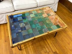 a coffee table made out of wood and glass on top of a hard wood floor