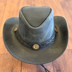 This hat is crafted from Crazy Horse Leather and features a braided band with conchos.  It includes a sweatband on the inside for comfort. Made with handcrafted leather for both men and women.  Its available in both tan and black natural leather colors.  It is unlined on the inside.  The wide brim of this leather hat provides shade in the sun.  You can make your own style as the brim of the hat is easily shapable. It is made from 100% pure leather. The hat is approximately 3" brim and 3 ½'' Crown in size. It has a distressed finish on all the leather.  It includes a chinstrap which is removable and adjustable to the customer's preference.  Please refer to the size chart as shown in the pictures to select the perfect size for you and to place an order with confidence. Rugged Leather Hat With Flat Brim, Rugged Leather Hat Bands, Rugged Leather Hats For Western-themed Events, Rugged Leather Hat Bands For Outdoor, Rugged Adjustable Leather Hat, Rustic Leather Hat Bands For Outdoor, Adjustable Rugged Leather Hat, Rustic Leather Fedora With Adjustable Fit, Western Style Hat With Leather Patch For Outdoor