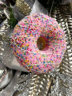 a pink donut with sprinkles hanging from it's center piece