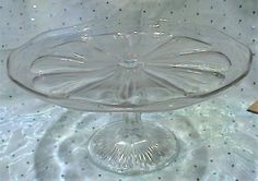 an empty glass cake plate on a table