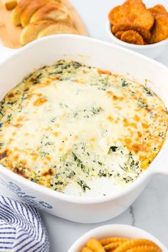 a casserole dish with cheese and spinach in it next to other dishes