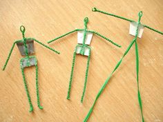 three pieces of green string art sitting on top of a wooden table