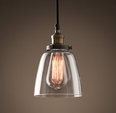 a clear glass light hanging from a ceiling fixture with a black cord attached to it