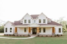 a large white house sitting on top of a lush green field