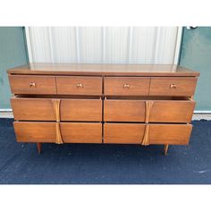 a large wooden dresser sitting on top of a blue carpeted floor next to a wall